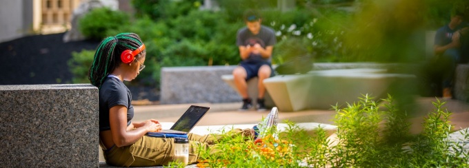 Student working on a computer at Grace Plaza outside Bell and Bonner Halls on North Campus. 