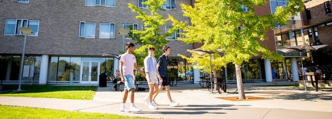 Students walking outside of Greiner Hall and the Ellicott Complex. 