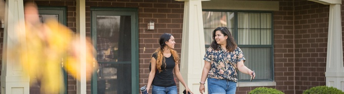 Two students walking outside of their Creekside Village apartment. 