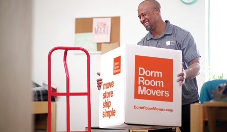 Professional mover moving a dorm room movers box for a student out of the dorm room.