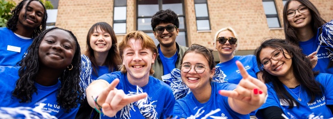 Cheerful students posing with pom poms.