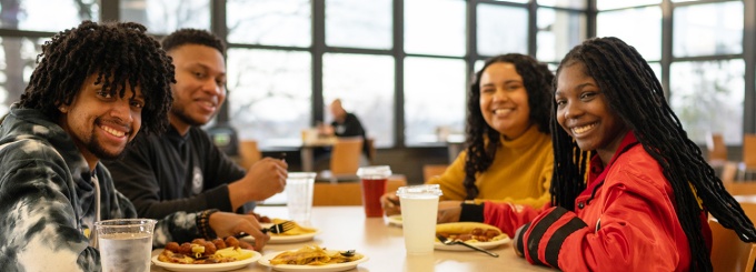 Students sitting at a dining hall table. 