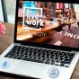 A laptop opened with virtual Live + Work, New York City website up on screen. 