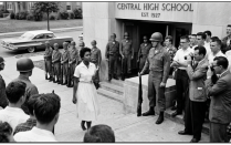 Elizabeth Eckford, an African American student, climbs the stairs to Central High School in Little Rock, Arkansas on the first day the school was integrated; she is flanked by members of the press and the National Guard.