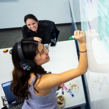 A student writing on a whiteboard.