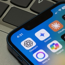 iPhone on a desk with generative AI applications shown.