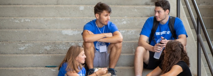 Students sitting on the stairs outside of Capen Hall during Honors College orientation. 