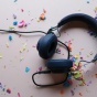 Photo of headphones on a table surrounded by confetti. 