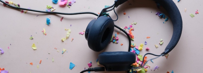 Photo of headphones on a table surrounded by confetti. 