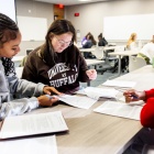 Students working around a table. 