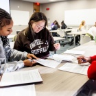 Students working around a table. 