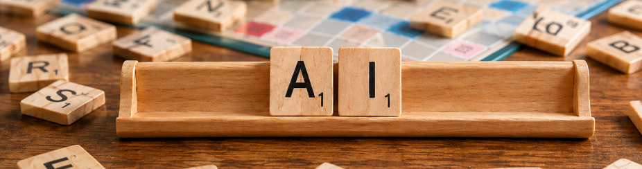 Close-up of a Scrabble-style board game on a wooden table, with scattered letter tiles surrounding a centered tile holder that displays the letters “A” and “I.”. 