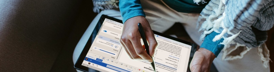 A woman writing on a tablet using a smart pen. 