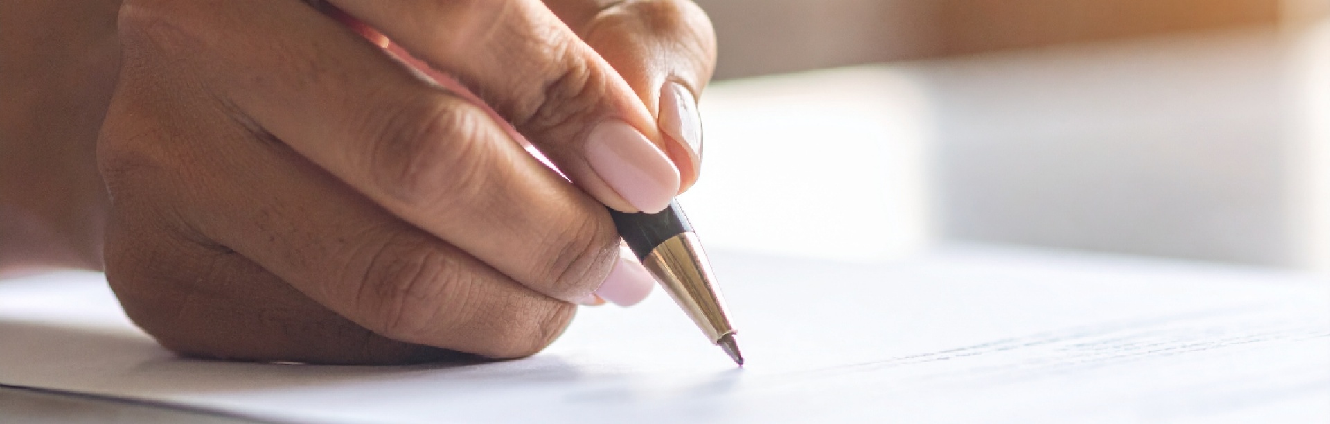 A person writing on a piece of paper. 