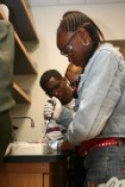 Two students work on pipetting in a wet lab.