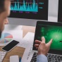 Two people looking at data on a laptop doing analysis. 