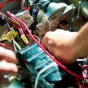 Two people's hands working on a robot. 