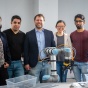 UB professor working on a robotic arm with Computer Science and Engineering students in a Davis Hall lab. 