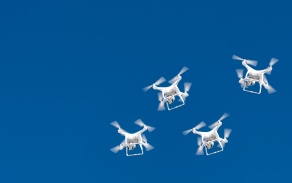 Swarm of drones in the blue sky. 