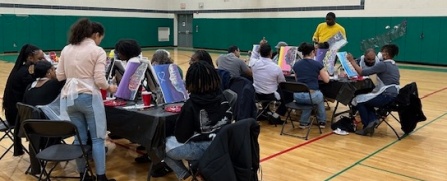 Two tables of 8 -10 people painting. 