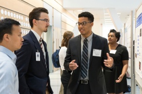 Jalen Bonitto, a student in the Institute for Strategic Enhancement of Educational Diversity Summer Research Experience program, explains his research to a pair of colleagues. 