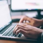 Hands typing a laptop computer. 