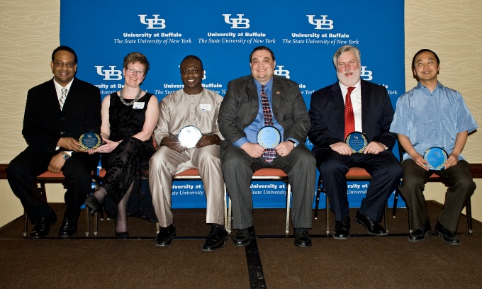 Faculty mentors seated with their awards. 