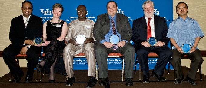 Faculty mentors seated with their awards. 