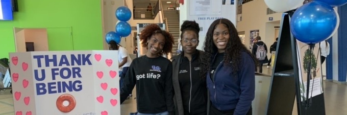 Students standing in the student union, posing for a picture during the organ donor registry and blood drive campaign. 