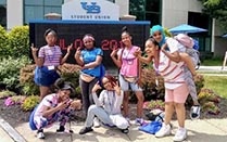 Group of students standing in front of UB's Student Union on a sunny day. 