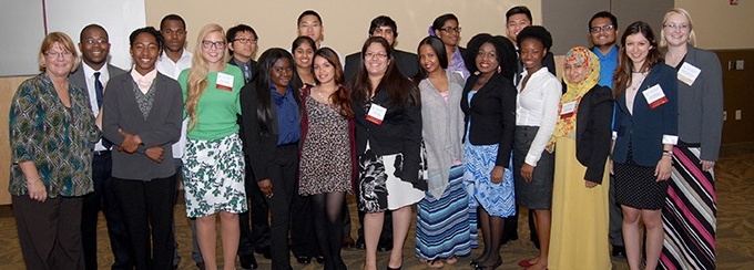 A group of 21 students and staff smiling and looking at the camera. 
