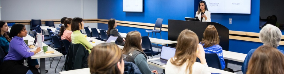 -Photo of a presentation at UB's North Campus watched by rows of students. 