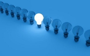 Blue-tinted photo of a row of light bulbs, with just one bulb lit up in the middle. 