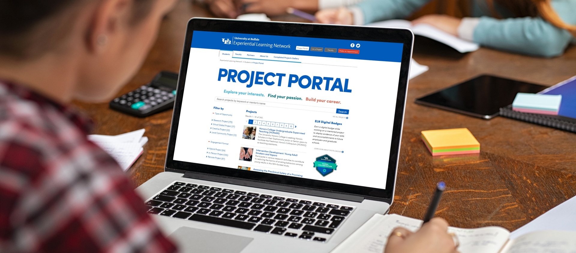 Student exploring Project Portal on laptop. 