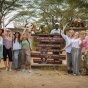 Students and faculty in front of a sign for Serengeti National Park. 