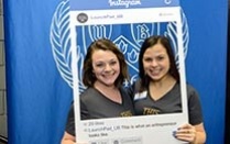 Two students at a Blackstone event with a large Instagram frame around them. 