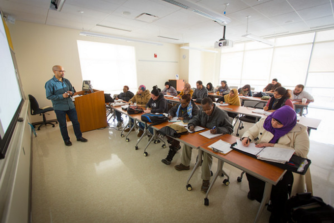 Person in front of a classroom full of students. 