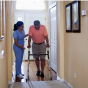 Home Health Aide helping a person walk. 