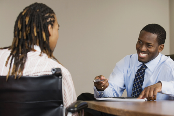 Two people having a conversation in a workplace. 