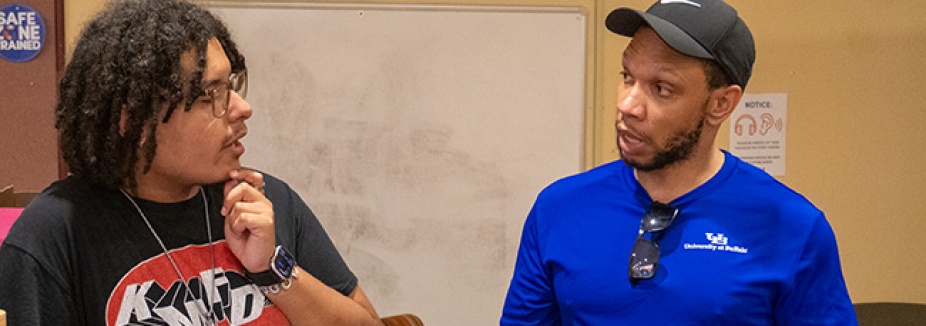Student speaking to an EOP staff member in a blue shirt.