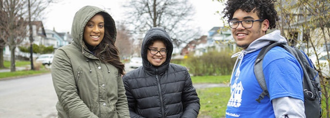 Three students volunteering together. 