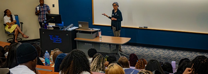EOP director speaking to a large group of students in a lecture hall. 