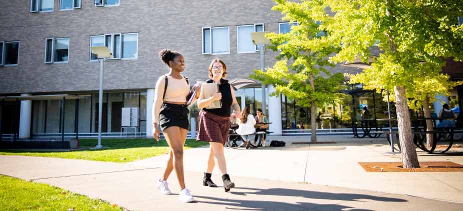 Students walking on a pathway outside Greiner Hall and the Ellicott Complex on UB’s North Campus. 