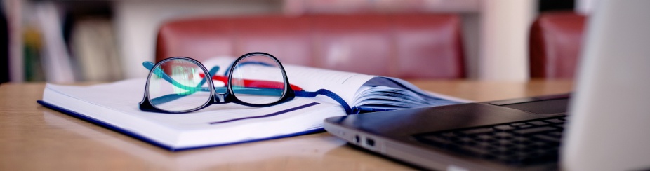 Office tools for school project: laptop, book, eyeglasses. 