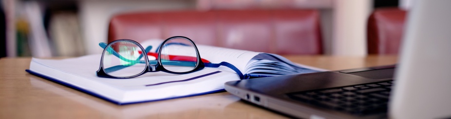 Office tools for school project: laptop, book, eyeglasses. 