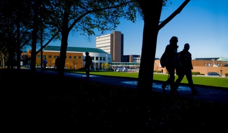 Two silhouetted figures walking on the North Campus. 