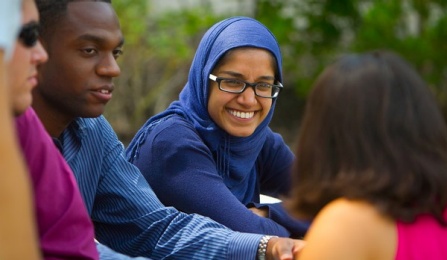 Dental students smiling, sitting outside. 