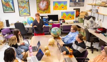 A faculty member speaks to a small group of students. 
