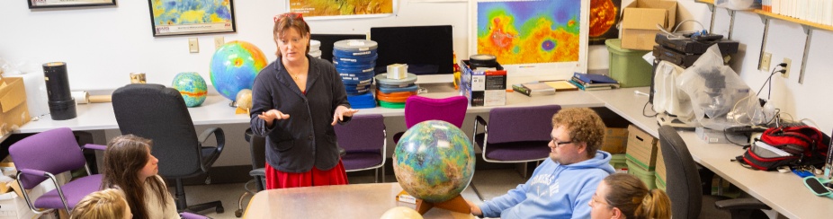 A faculty member speaks to a small group of students. 