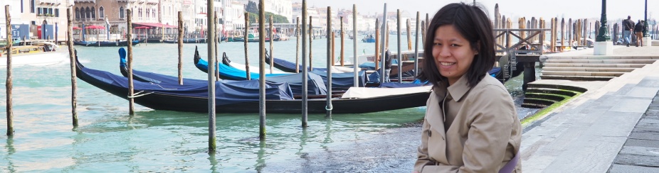 Sharon Lin sitting on a dock next to a body of water. 